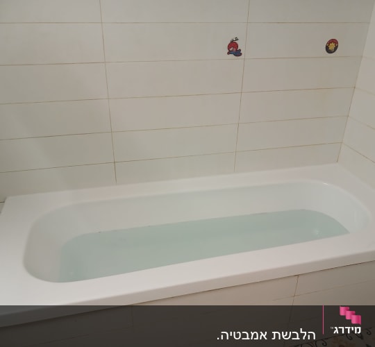 אמבטיה עם אריחים לבנים ודמויות מצוירות
